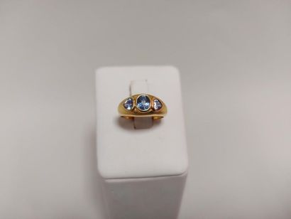 null Yellow gold ring set with a faceted oval sapphire and 2 Ceylon pear sapphires....