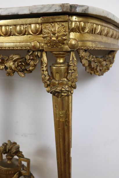 null Console en bois mouluré, sculpté et doré, à décor de cannelures et de fleurs...