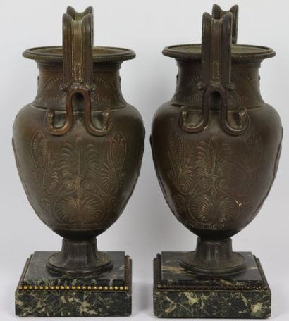 null Paire de vases à l'antique en régule à patine brune et dorée.

Les anses en...