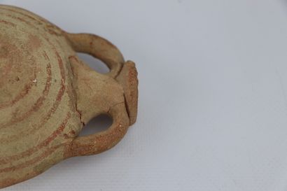 null Antique terracotta flask with flattened body and concentric patterns.

H_12.5...