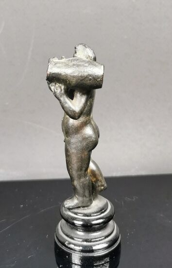 null Small antique bronze with antique patina showing a man holding an amphora on...