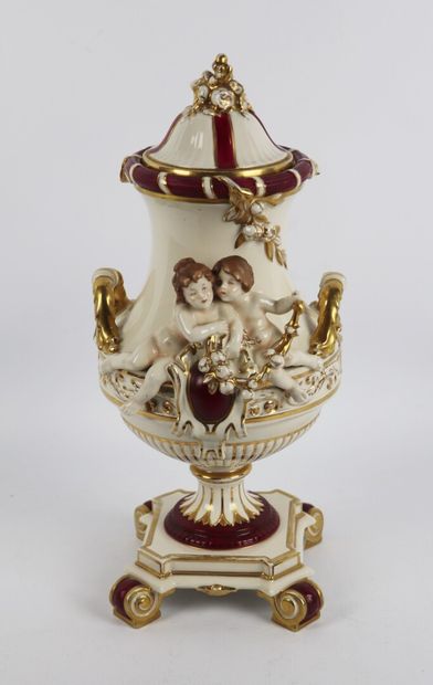 null Vase couvert en porcelaine à décor de deux amours tenant une guirlande, surmontant...