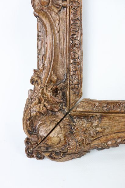 null A molded and carved wooden frame decorated with medallions and flowers in the...