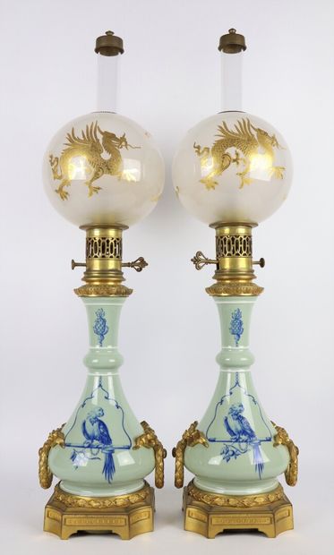 null Paire de lampes à pétrole en porcelaine à décor de perroquets perchés. 

Les...