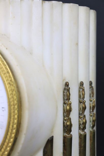 null White marble and bronze clock simulating a column. 

The enamelled dial signed...