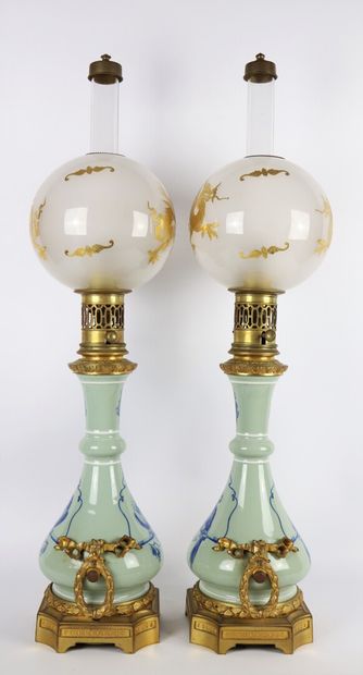 null Pair of porcelain oil lamps with perched parrots. 

The handles and the base...