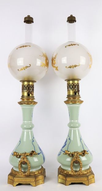 null Pair of porcelain oil lamps with perched parrots. 

The handles and the base...