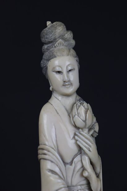 null CHINE, vers 1900-1920.

Guanyin en ivoire sculpté tenant un bouquet.

H_27,5...