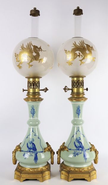 null Pair of porcelain oil lamps with perched parrots. 

The handles and the base...