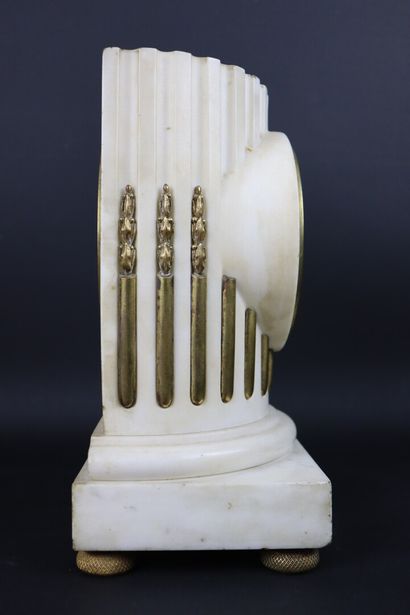 null White marble and bronze clock simulating a column. 

The enamelled dial signed...