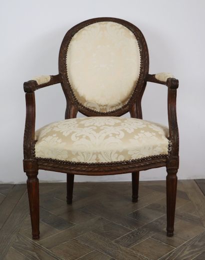 null Two beechwood medallion back armchairs molded and carved with flutes and leaves.

Louis...