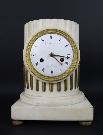 null White marble and bronze clock simulating a column. 

The enamelled dial signed...