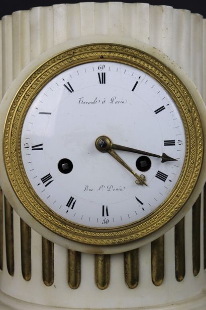 null White marble and bronze clock simulating a column. 

The enamelled dial signed...