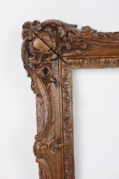 null A molded and carved wooden frame decorated with medallions and flowers in the...