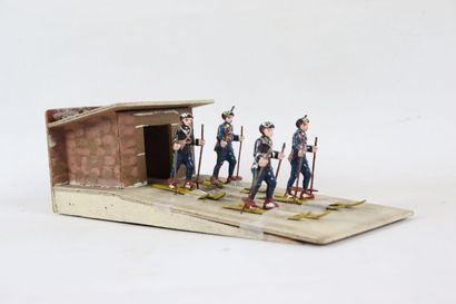 null Maquette figurant quatre chasseurs alpins en aluminium peint sortant d'un cabanon...