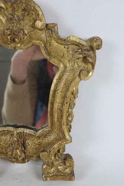 null Miroir en bois en stuc doré, de forme chantournée, à décor d'enroulements et...