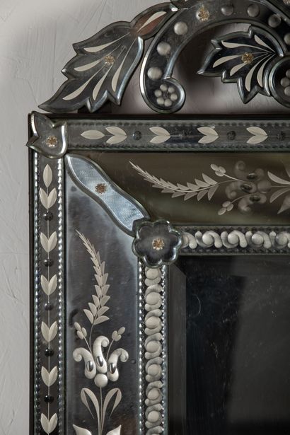 null Important miroir dit vénitien en verre gravé à décor floral. 

Le fronton à...
