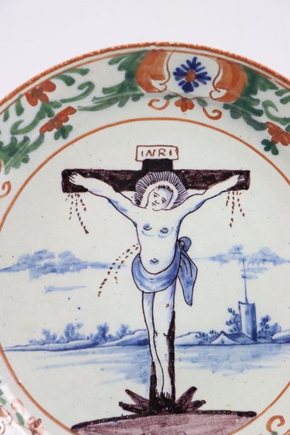 null DELFT. 

Assiette en faïence à décor polychrome de la crucifixion. 

XVIIIème...