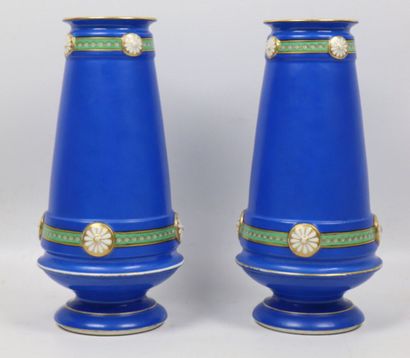 null PARIS. 
Paire de vases en porcelaine à décor d'amours au ruban, sur fond bleu....