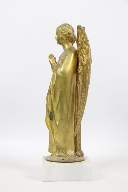 null Angel in gilded bronze. 
It rests against a column and on a round base. 
The...