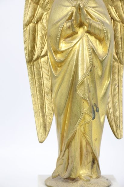 null Angel in gilded bronze. 
It rests against a column and on a round base. 
The...