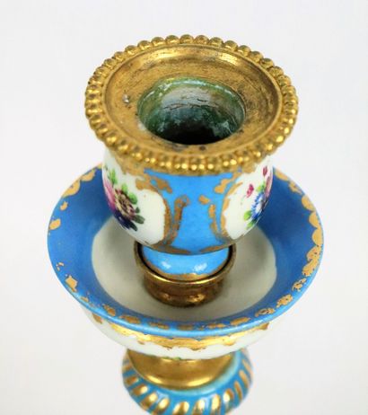 null SEVRES, in the taste of. 
Two porcelain candlesticks on an azure blue background....