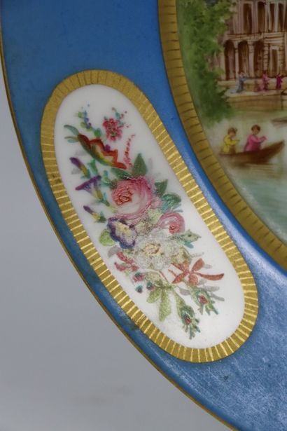 null SEVRES.
Reunion of two blue and gold porcelain plates with painted central decoration...