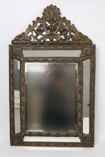 null Miroir à pare-closes en laiton repoussé à décor feuillagé.
Style Louis XIII,...
