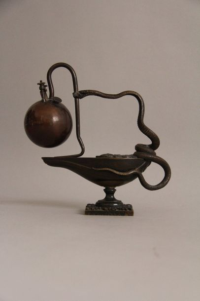 null Porte-briquet en bronze à patine marron en forme de lampe à huile sur piédouche.
H...