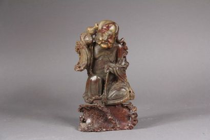 null Soapstone subject representing a crouching Luohan leaning on a stick.
China,...