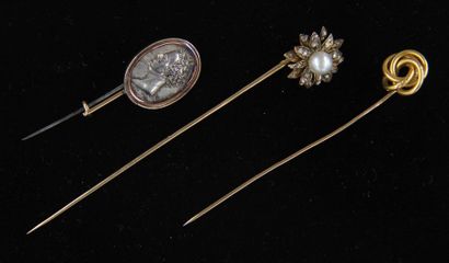 null Trois épingles à cravate en or 18k :
- une en forme de fleur sertie d'une perle...