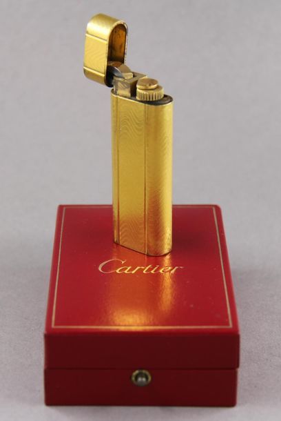 null Must de CARTIER
Briquet en métal doré guilloché (petits chocs), dans sa boite...