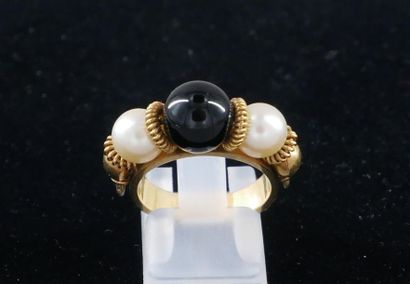 null *Yellow gold ring set with two cultured pearls framing a black ball, TDD: 52...