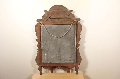 null *Moving gilded carved wood mirror on a gray background with a pediment decorated...