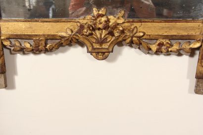 null *Moving gilded carved wood mirror on a gray background with a pediment decorated...