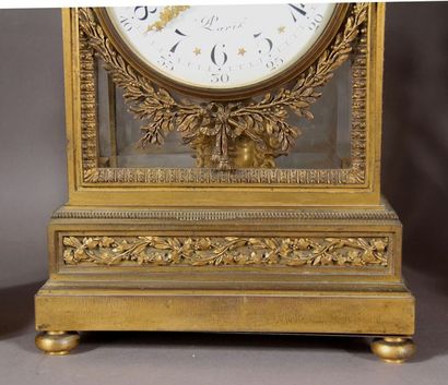 null Cage clock in chased and gilded bronze, topped by an urn decorated with ram's...