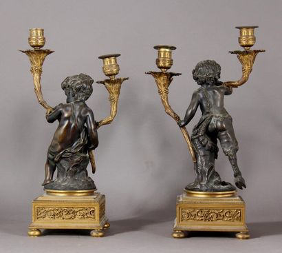 null Pair of small candelabra in gilt bronze and bronze with brown patina, representing...