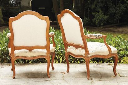 null Pair of armchairs in moulded and sculpted beech wood, the shouldered backrest...