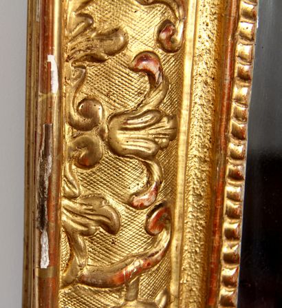 null *Glace rectangulaire en bois sculpté doré à fronton ajouré rapporté, XVIIIème...
