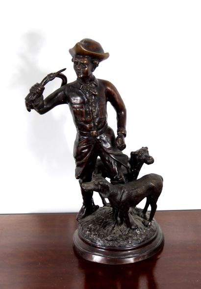 null *Sculpture en métal patiné représentant un chasseur avec son cor et deux chiens.

H...