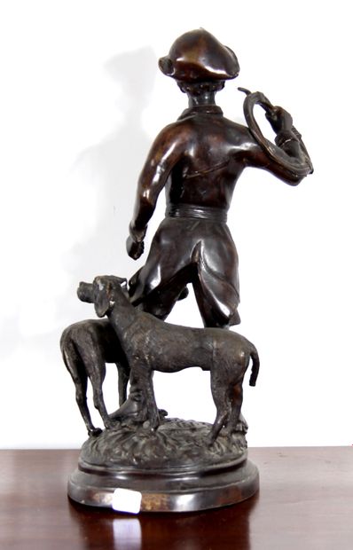 null *Sculpture en métal patiné représentant un chasseur avec son cor et deux chiens.

H...