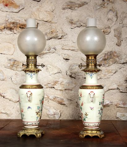 null Paire de lampes à pétrole en céramique à décor polychrome et or sur fond légèrement...