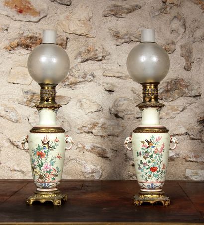 null Paire de lampes à pétrole en céramique à décor polychrome et or sur fond légèrement...