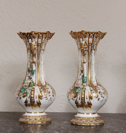 null A pair of white and gilt porcelain openwork vases on a pedestal, with two handles...