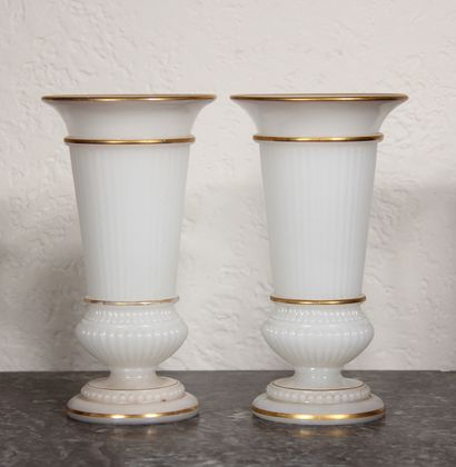 null A pair of fluted vases on a pedestal in white opaline glass with gold edging.

H...