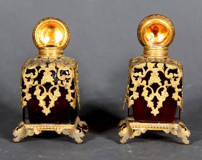 null Pair of cubic perfume bottles, quadripod in red transparent glass, with openwork...