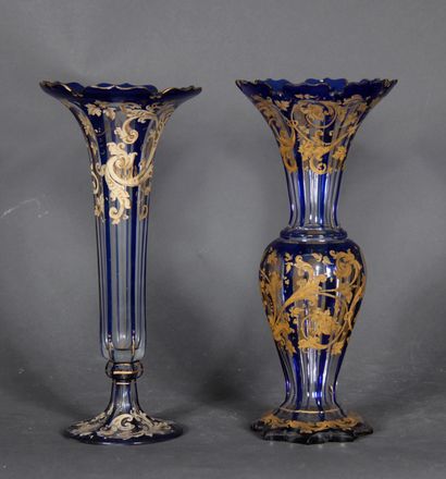 null Two transparent and blue overlay glass vases with white and gilded scroll decoration.

H...