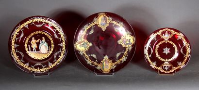 null Trois plats ronds en verre transparent rouge à décor de feuillage doré et personnages...