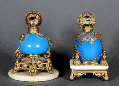 null Two blue opaline glass perfume bottles, brass frame. 

Stoppers decorated with...
