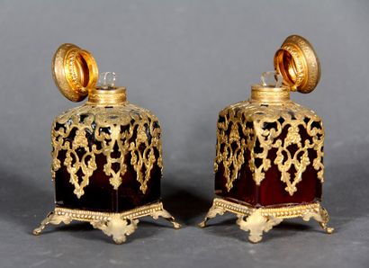 null Pair of cubic perfume bottles, quadripod in red transparent glass, with openwork...